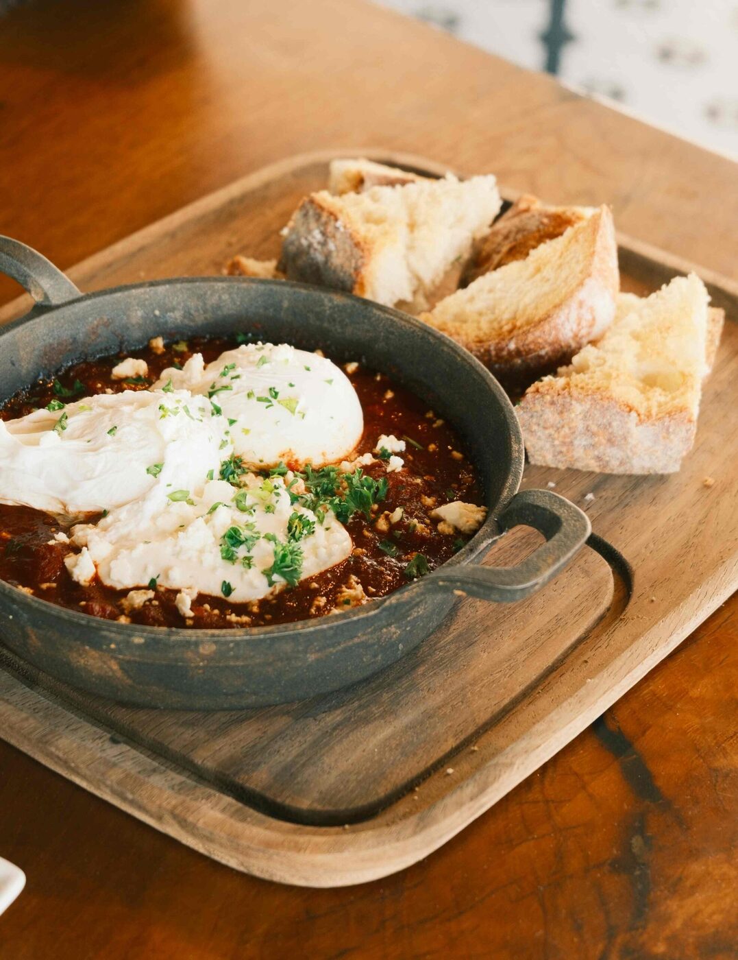 Shakshuka — eggs poached in spiced tomato with warm house sourdough at bai-tee