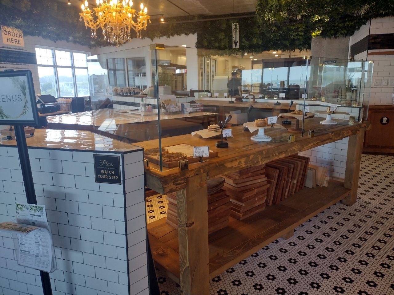Inside bai-tee — chandelier, white subway tile, reclaimed wood bakery counter